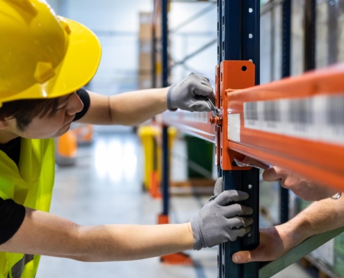 Worker installing pallet racks in warehouse